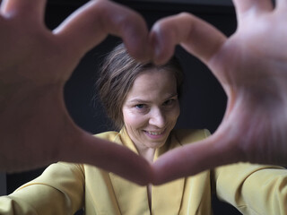 portrait of woman showing heart sign with hands