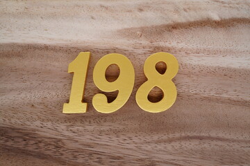 Golden Arabic numerals on real wood with brown and white pattern.