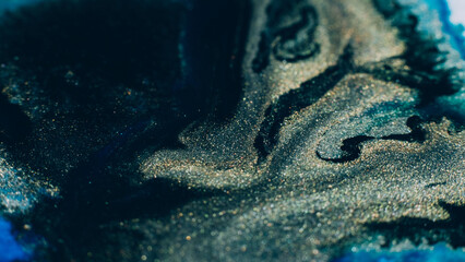 Ink background. Abstract colorful design. Creative paint mixture. Blue gold black colors blend