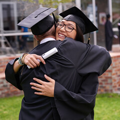 Lifes great moments. Shot of two students hugging on graduation day.