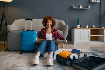Woman reading travel map surrounded with luggage