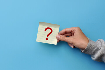 A question mark in a person's hand. Symbol of doubt, problems