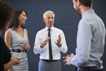 Enjoying some comic relief with the boss. Shot of a group of professional coworkers having a discussion.
