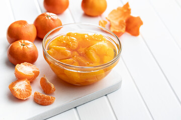 Canned tangerine. Pickled mandarin fruit in bowl on white table.