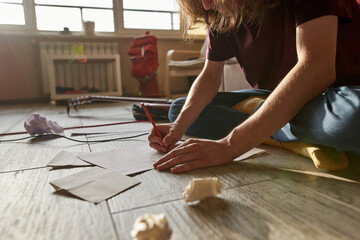 Cropped image of man writing text of song at home