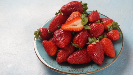 Strawberry fresh organic fruit in a plate. Strawberries with leaves. Isolated on a grey background.