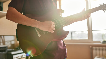 Cropped of man playing notes on electric guitar