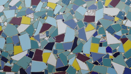 Fototapeta na wymiar Colorful abstract ceramic mosaic. Close up. Mosaic on the wall with fragments of blue, white, black colors with pieces.