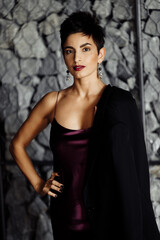 Fototapeta premium Portrait of serious elegant female leader look at the camera, wearing stylish dress. Beautiful elegant business woman posing with cross hands, attractive gorgeous lady boss show confidence and success