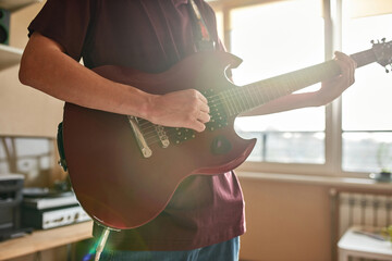 Partial of man playing notes on electric guitar
