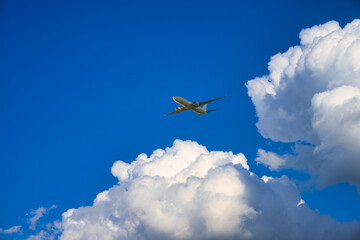 Fototapeta na wymiar 白い入道雲の間を飛行する航空機