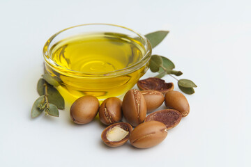 Argan seeds and oil isolated on a white background. Argan oil nuts with plant. Cosmetics and natural oils background