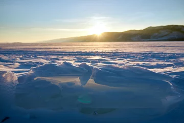 Fotobehang Ice hummocks on Baikal Lake in a sunny day. Winter landscape with beautiful transparent ice floes on foreground. © truba71