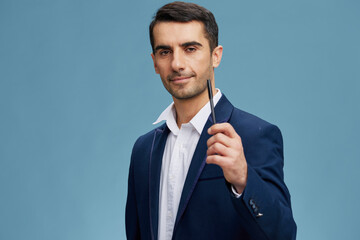 businessmen pen in hand in a stylish suit posing self-confidence blue background