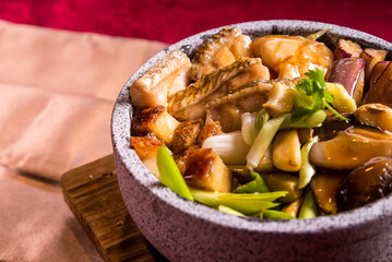 stir fried grouper fish slices in soy sauce on hot stone pot red cloth background chinese halal menu