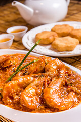 stir fried prawn seafood with spicy chilli crab egg thick gravy sauce and deep fried man tofu bun on bamboo wood table tea pot asian Chinese halal food restaurant banquet cuisine cafe menu