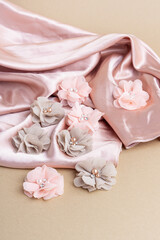 Fabric flowers on pink silk fabric. Flowers for creativity and sewing