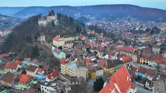 flying above historic medieval town of Sighisoara, aerial view of famous tourist destination in Romania, scenic unesco heritage site in Transylvania in winter