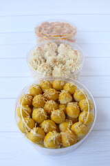 A jar of Nastar (Dutch pineapple tarts) with two other blurry cookies on the background
