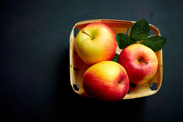 Bright apples with leaves on a black background