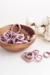 Obraz na płótnie Canvas Set of soft elastic bands for hair in wooden bowl on white background. Comfortable elastic bands. Cotton flowers on background