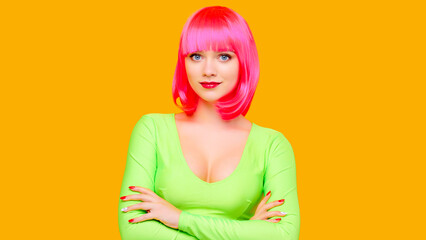 Young attractive sexy charming woman in pink wig with beautiful big breasts on yellow background