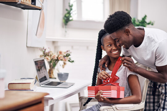 I Cant Wait For You To See What I Got You. Shot Of A Young Man Surprising His Girlfriend With A Present At Home.