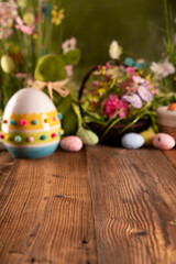 Fototapeta na wymiar Easter time. Easter decorations on the rustic wooden table. Easter bunny, easter eggs in basket. Bouquets of spring flowers. 