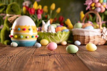 Easter time. Easter decorations on the rustic wooden table. Easter bunny, easter eggs in basket. Bouquets of spring flowers. 