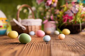 Easter time. Easter decorations on the rustic wooden table. Easter bunny, easter eggs in basket. Bouquets of spring flowers. 