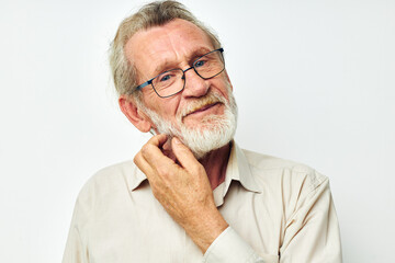 Photo of retired old man with a gray beard in a shirt and glasses light background