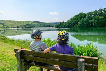 Zwei ältere Menschen genießen die sommerliche Natur bei einer Radtour 