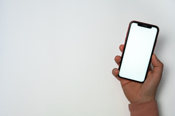 Man holding mobile phone with one hand. watching videos online or making a video call on white background. Concept of being hooked on social networks and video games.