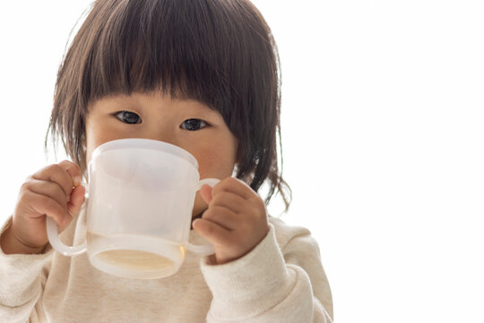 コップでお茶を飲む赤ちゃん（1歳8か月、女の子、日本人）