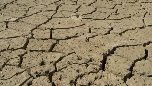 Riverbed of a lake cracked by drought, tilt