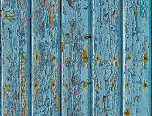 Vertical strips of wood with cracked and peeling blue paint