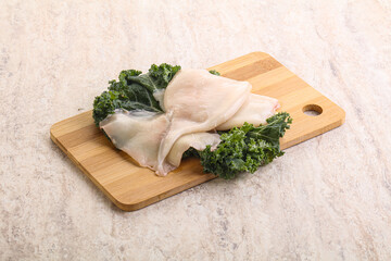 Raw squid over wooden board