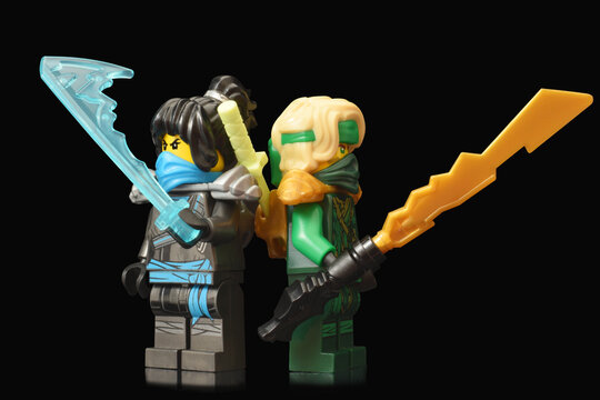 Foto de Editorial illustrative image of lego ninjago minifugure green ninja  Lloyd with sword weapon and water ninja Nia on black background with  reflexion do Stock | Adobe Stock