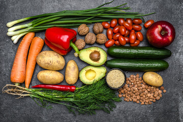 Healthy food background. Healthy vegetarian food. Vegetables and fruits on black stone. Clean vegetarian eating concept.