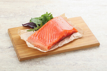 Raw salmon fillet over board