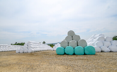 Hay bales on a rural countryside farmland ready for livestock wrapped in plastic
