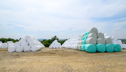 Hay bales on a rural countryside farmland ready for livestock wrapped in plastic