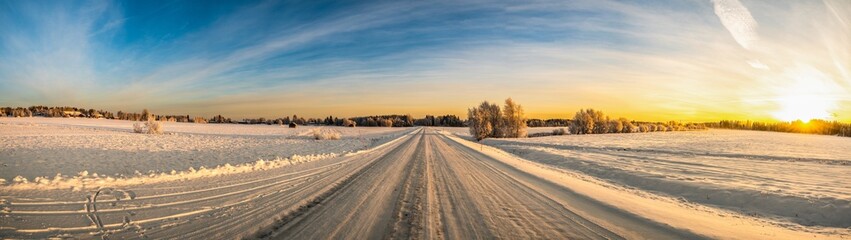 A panoramic sunshine horizon view of winter landscape with snow covered pine trees and clear blue sky during the touristic visit
