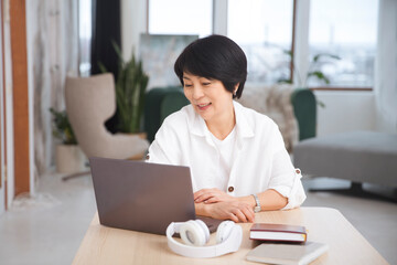 healthy lifestyle. work from home. The adorable Asian businesswoman sits on a laptop in the office.