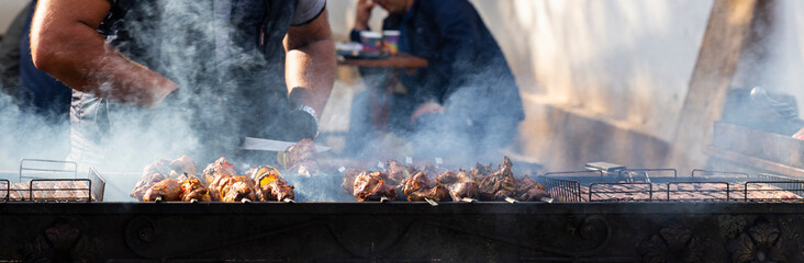 Roasting meat on the grill. Cooking fast food on the street.