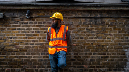 Portrait of an Asian construction worker wearing hard hat and high visibility vest.