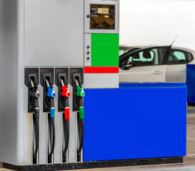 Fuel pump with fill nozzles colored black, blue, red and green, background energy crisis concept