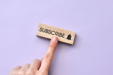 A wooden plate and a bell icon with the inscription subscribe in it. Internet channel subscription...