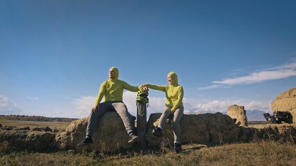 The man and woman travel on mixed terrain cycle touring with bikepacking. The two people journey...