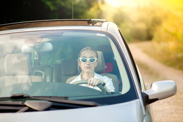 Attractive young woman driving her car. Portrait of a successful business woman